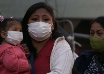 Una mujer carga a su hijo. El desempleo afectó más al ámbito femenino. Foto: ONU